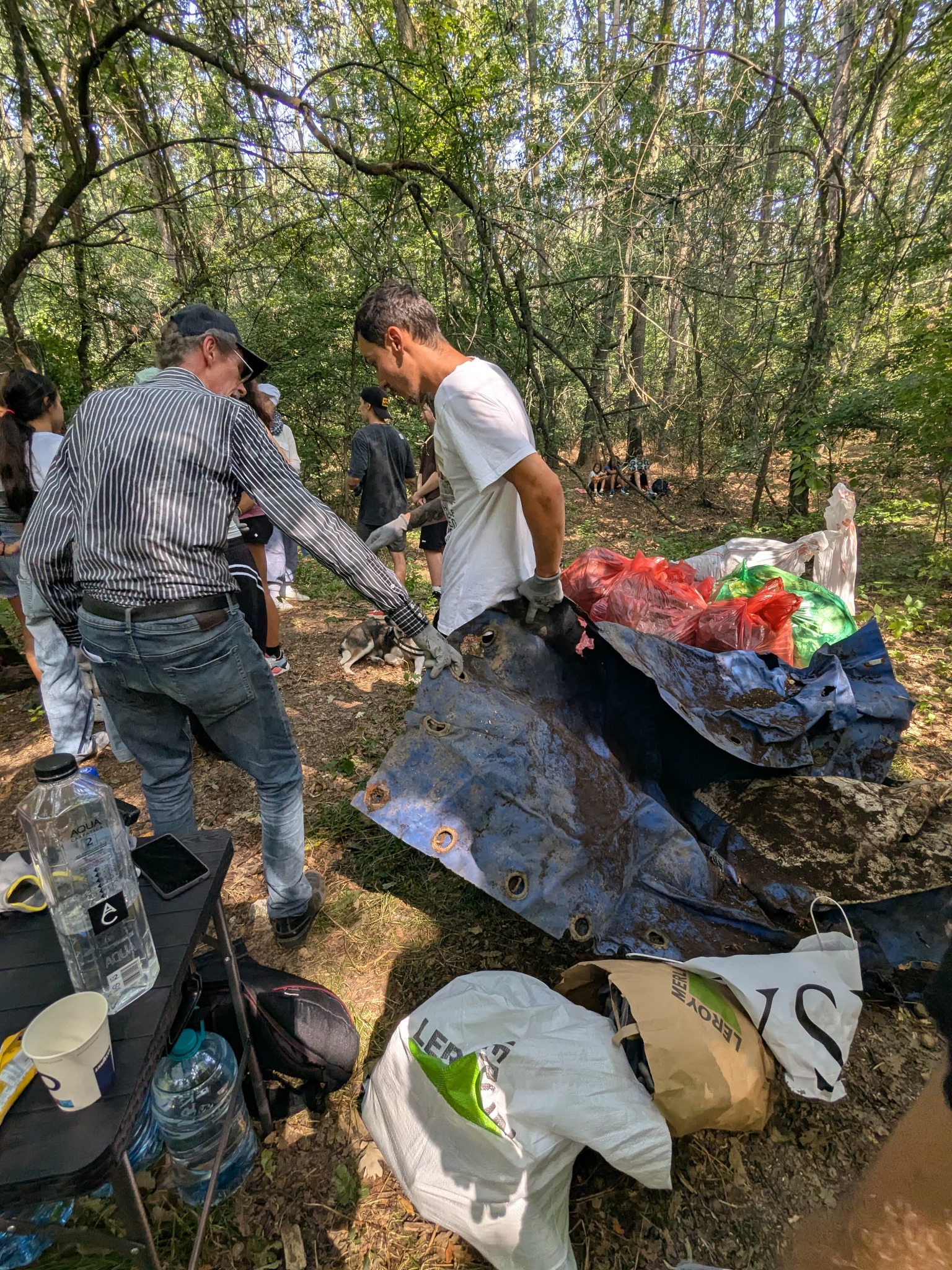 Voluntari scoțând un obiect mare găsit în pădure