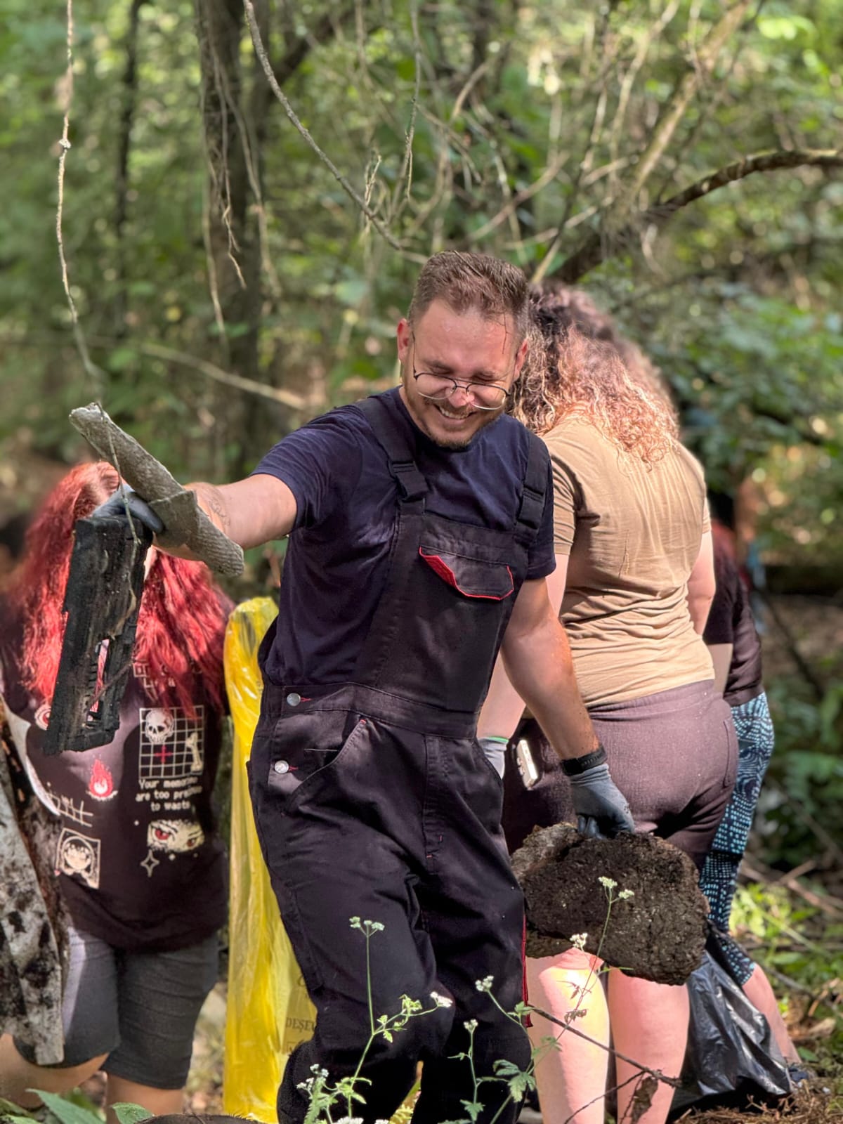 Voluntar ridicând deșeuri găsite în pădure