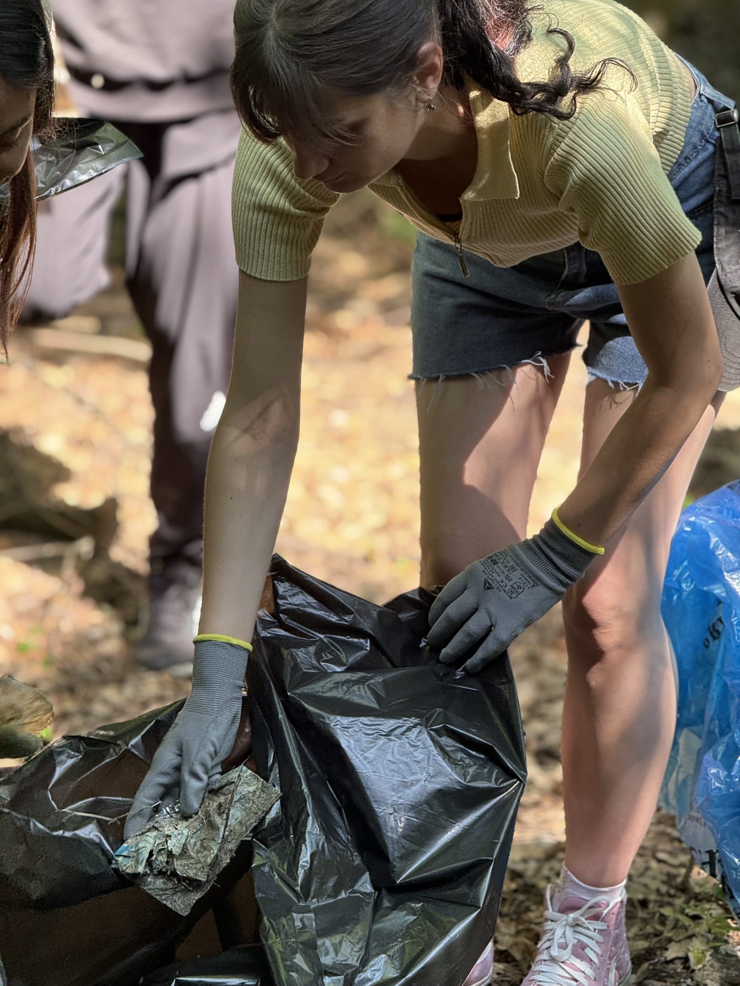 Voluntară sortând deșeuri într-un sac