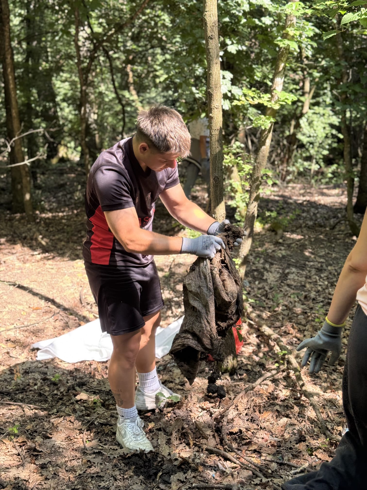 Voluntar scoțând un material degradat din pământ