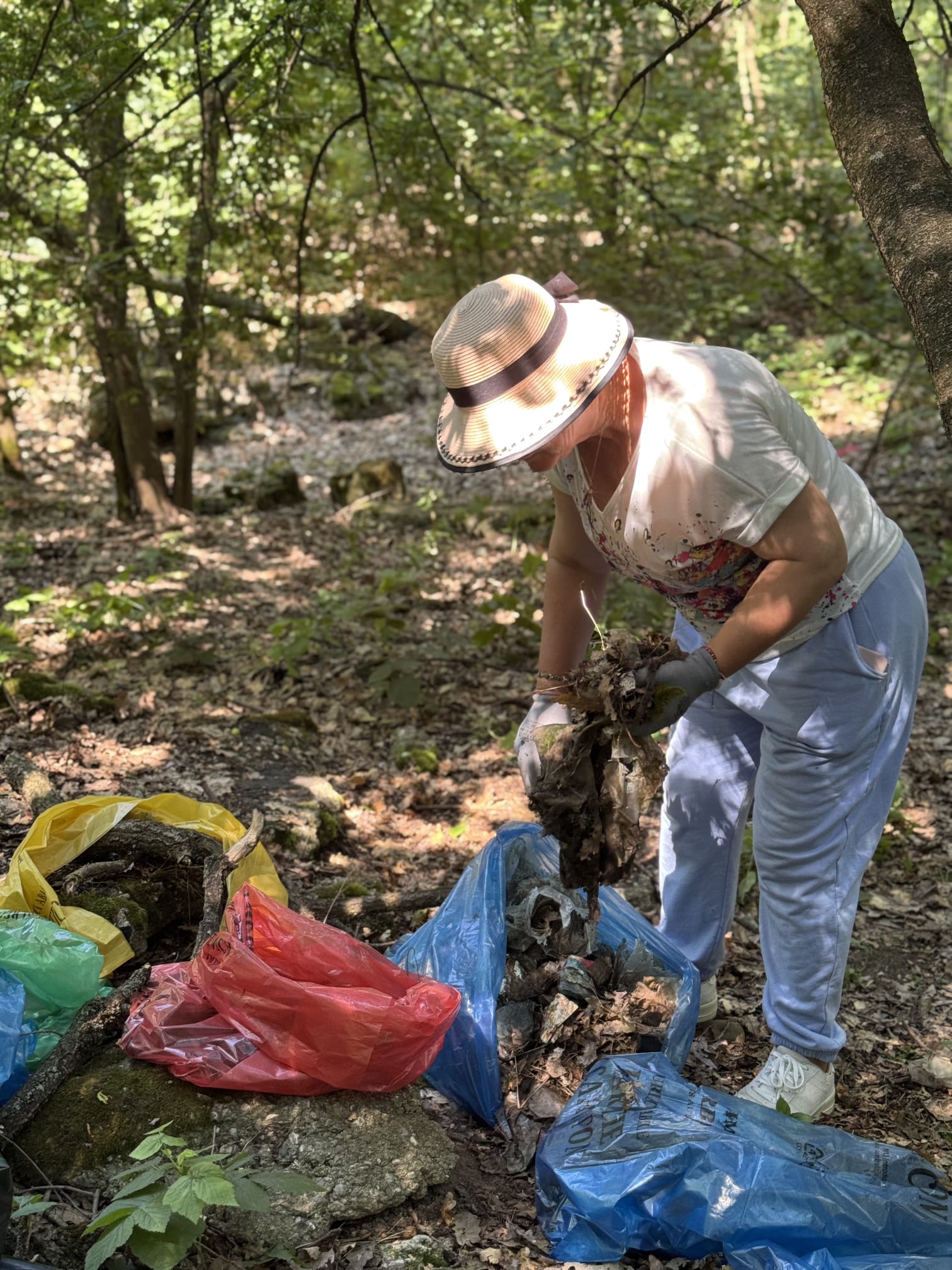 Voluntară colectând materiale murdare din pădure